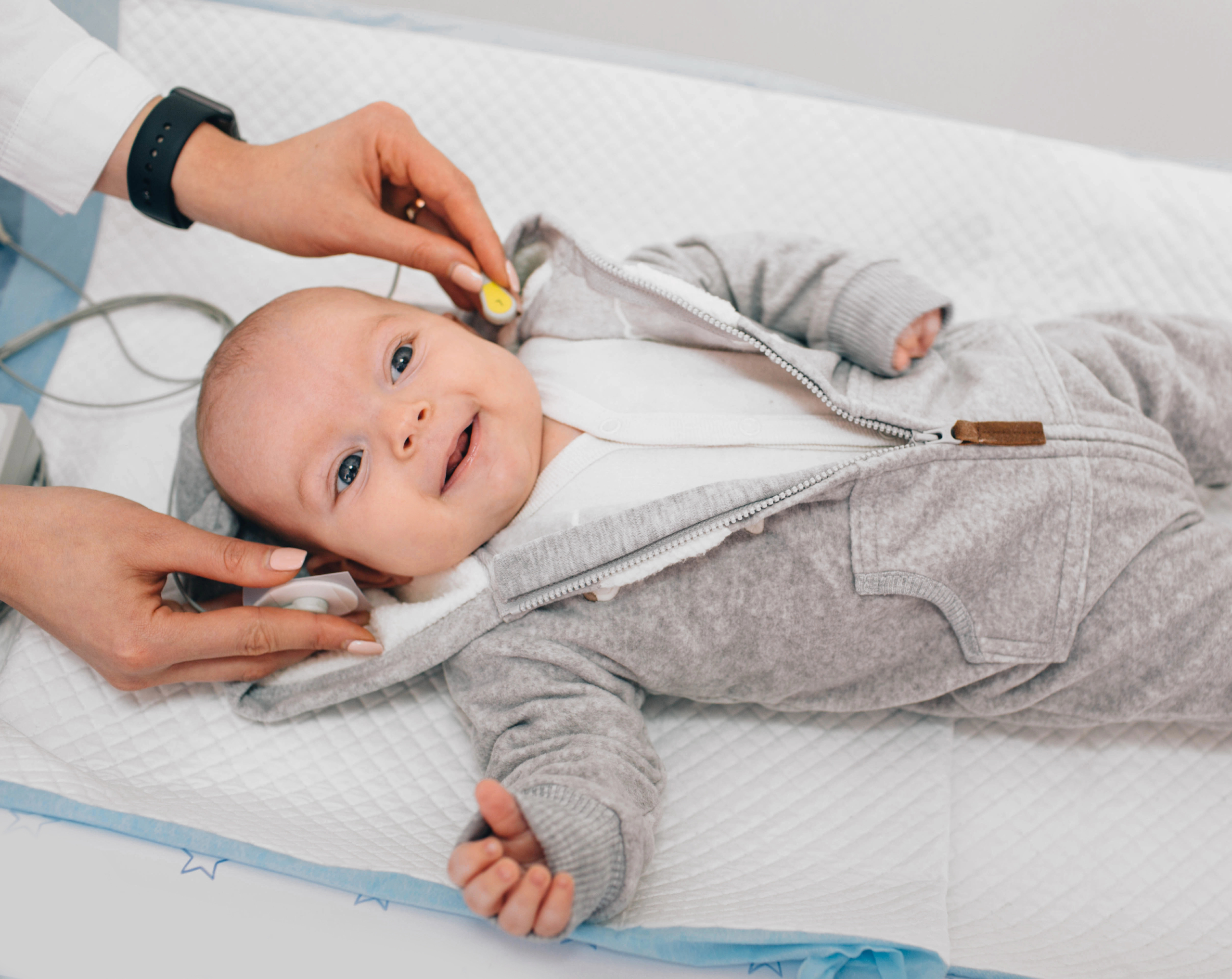 Pediatra realizando tamiz auditivo neonatal a un bebé.