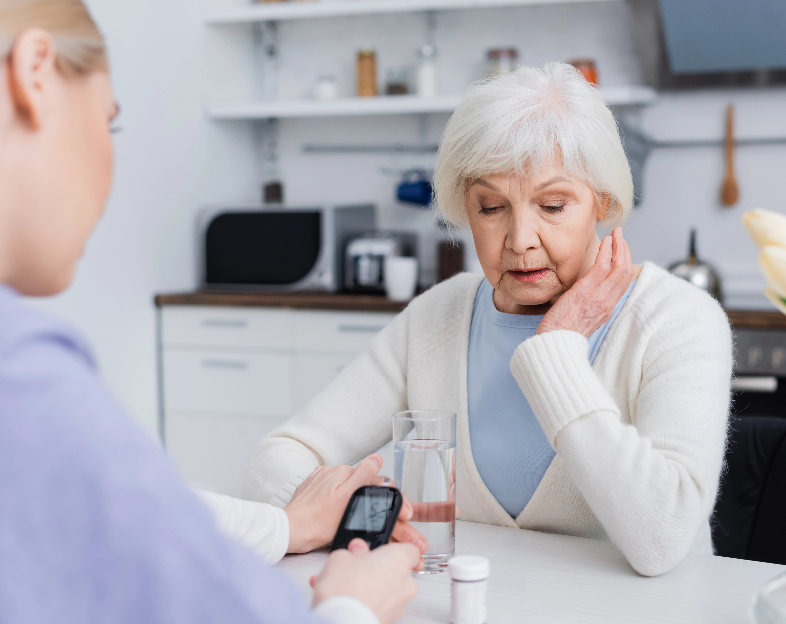 Profesional de la salud midiendo la glucosa en sangre de una paciente de diabetes mellitus.
