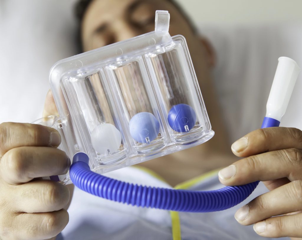 paciente sostiene espirómetro para rehabilitación pulmonar