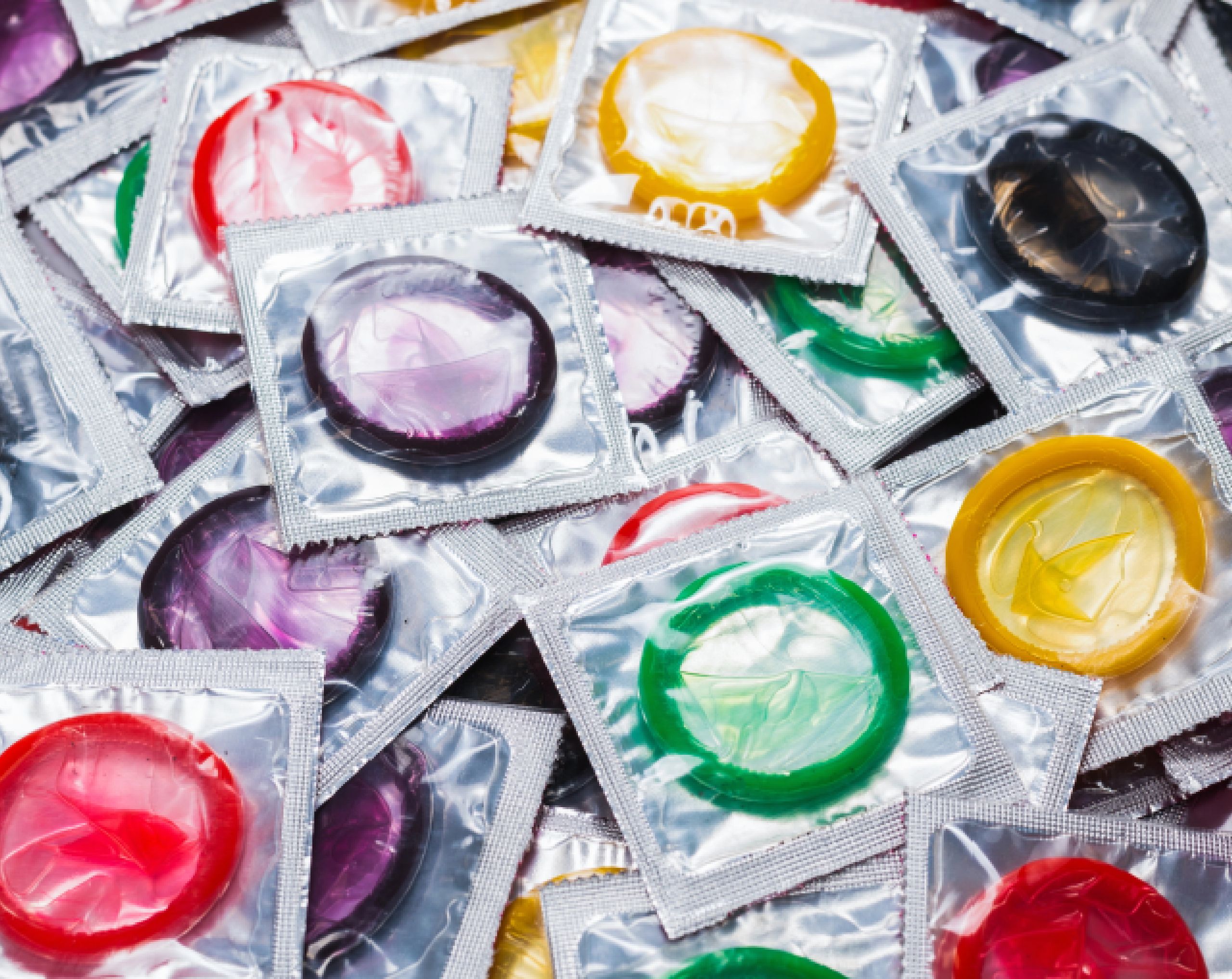 Varias envolturas de preservativos de colores, ya que el condón ayuda a prevenir embarazos y enfermedades de transmisión sexual, como el VIH.