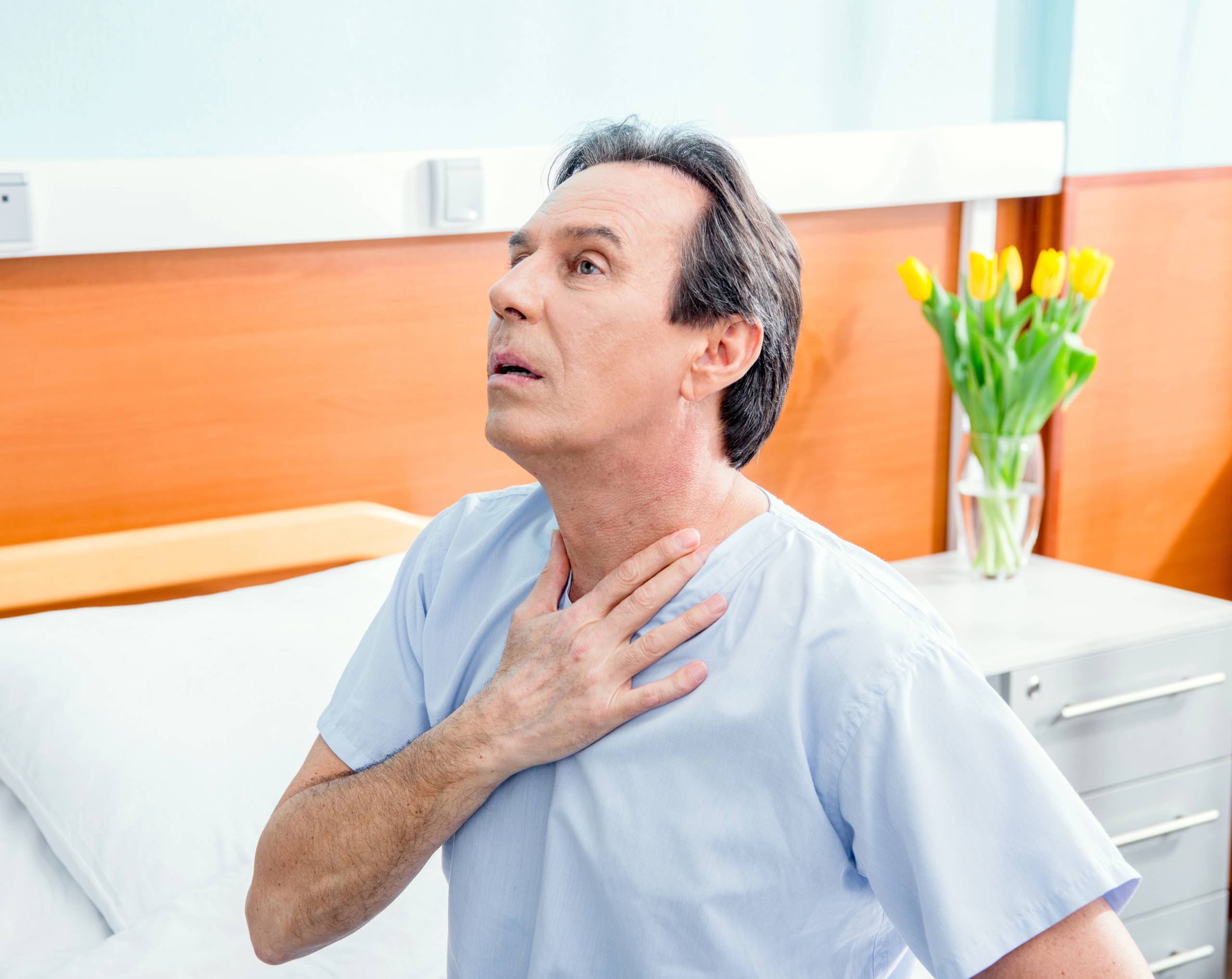 Hombre de edad media se toca el pecho por dolor con riesgo de una angina de pecho