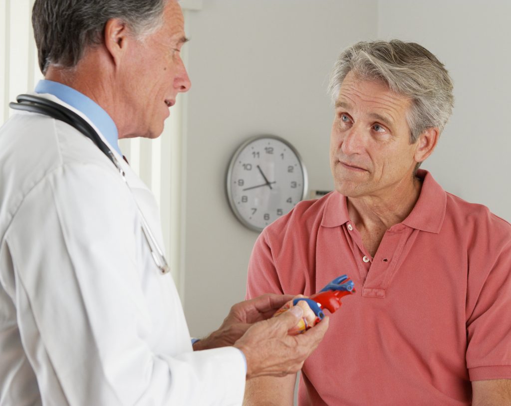 Hombre de edad media en el consultorio del cardiólogo, en revisión por posible infarto.