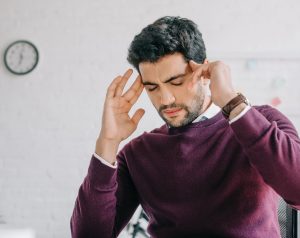 Hombre de mediana edad en su oficina presenta dolor de cabeza asociado a la hidrocefalia.