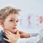 Niño de 6 años en consulta médica con inflamación de las mejillas, síntoma característico de las paperas.