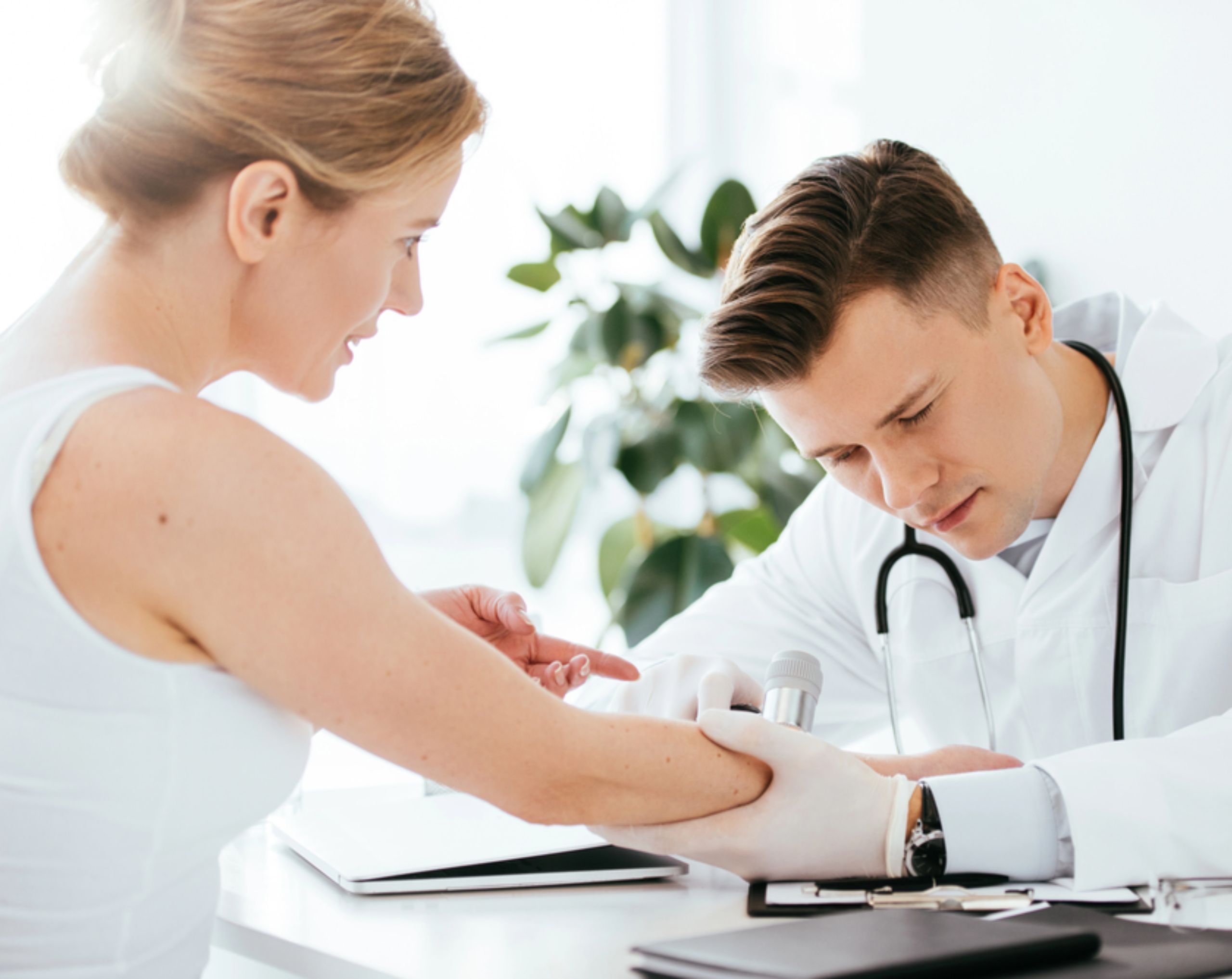 Dermatólogo revisa brazo de paciente con psoriasis. 