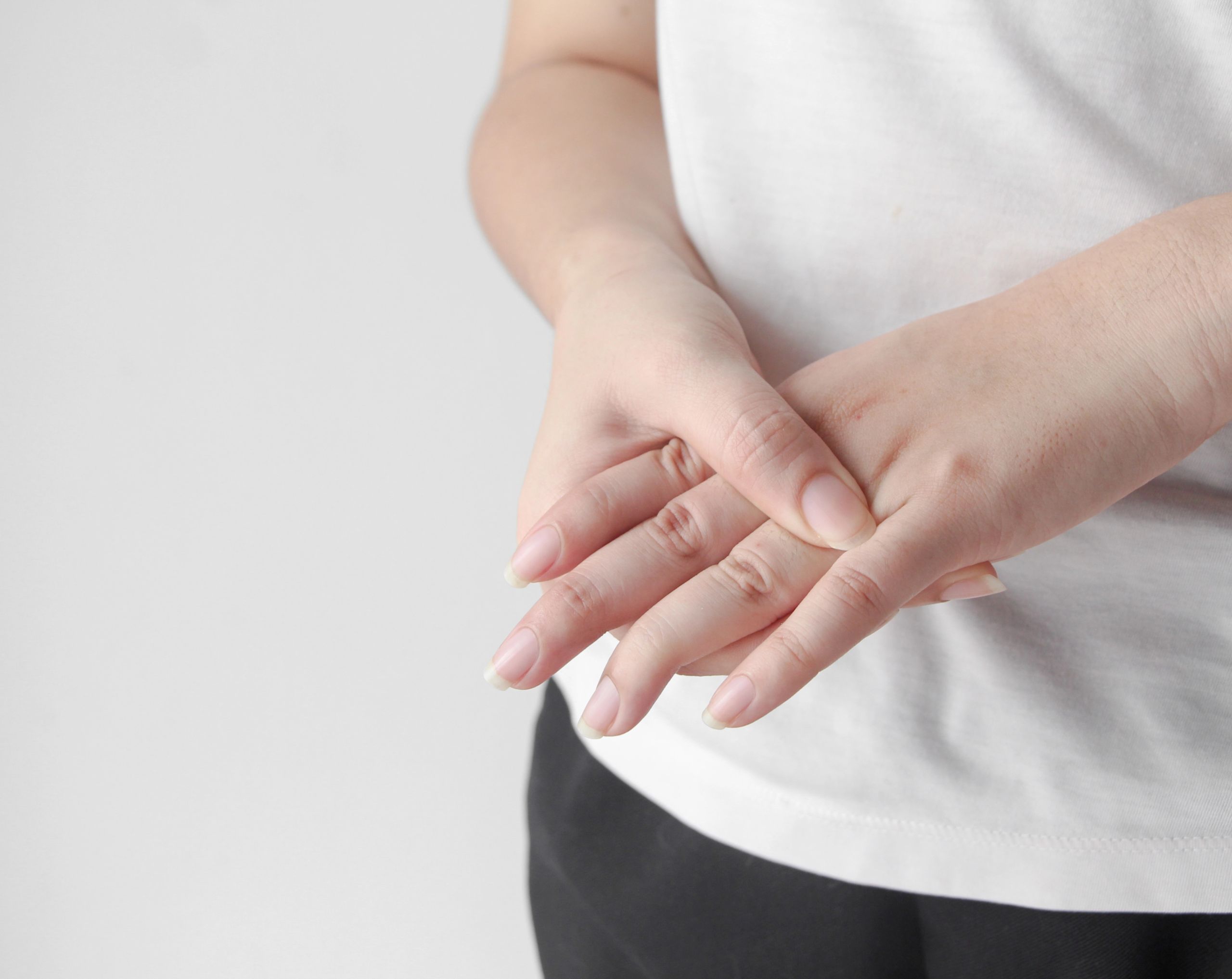 Mujer de mediana edad sobando los dedos de la mano por dolor causado por una lesión, que puede aliviarse con magnetoterapia.