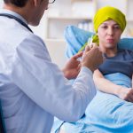 Mujer en camilla hospitalaria recibiendo inmunoterapia para combatir con mayor eficicacia el cáncer.