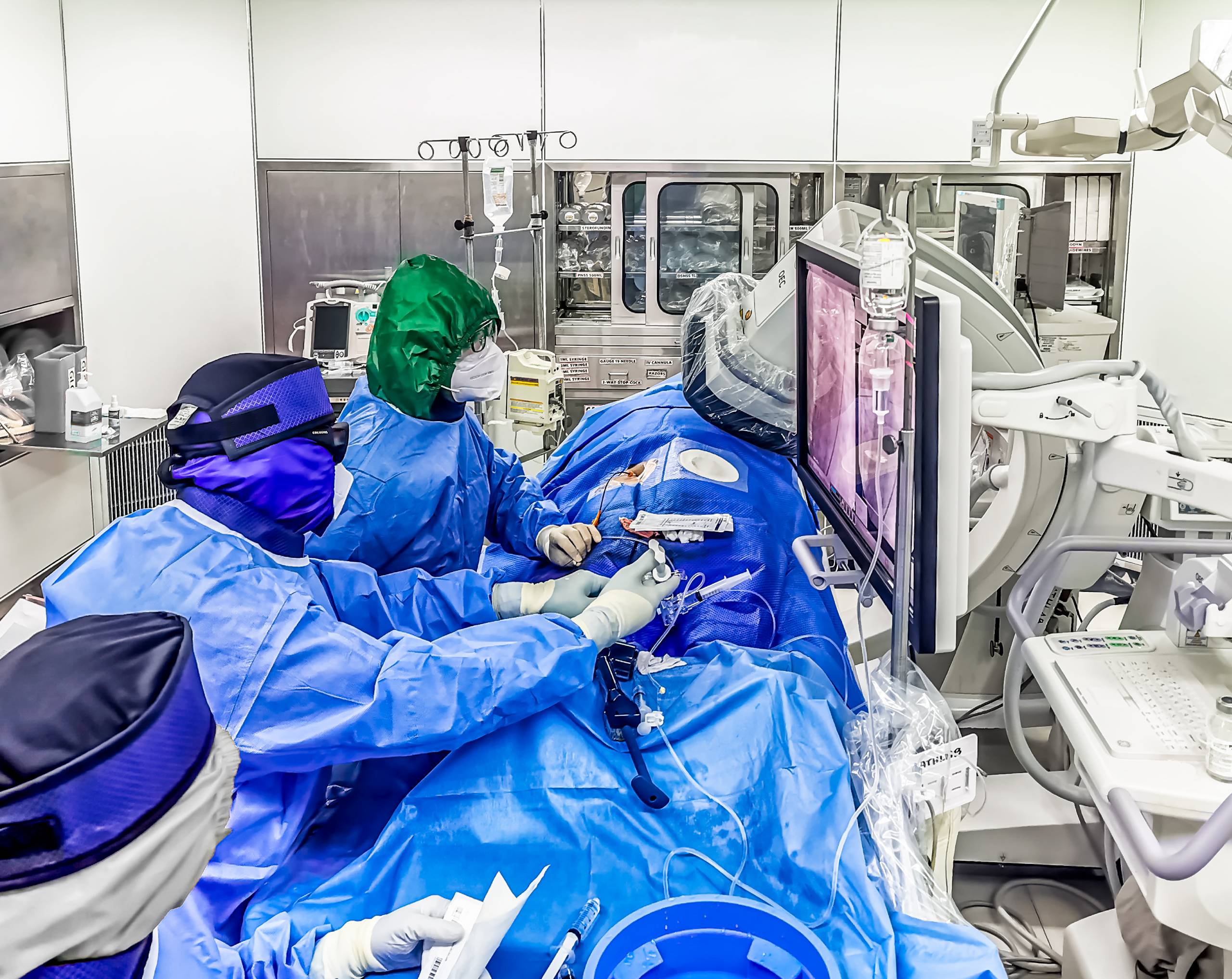 Radiólogos intervencionistas utilizando equipo de protección realizan una embolización arterial en la sala de hemodinamia de Hospital Angeles.