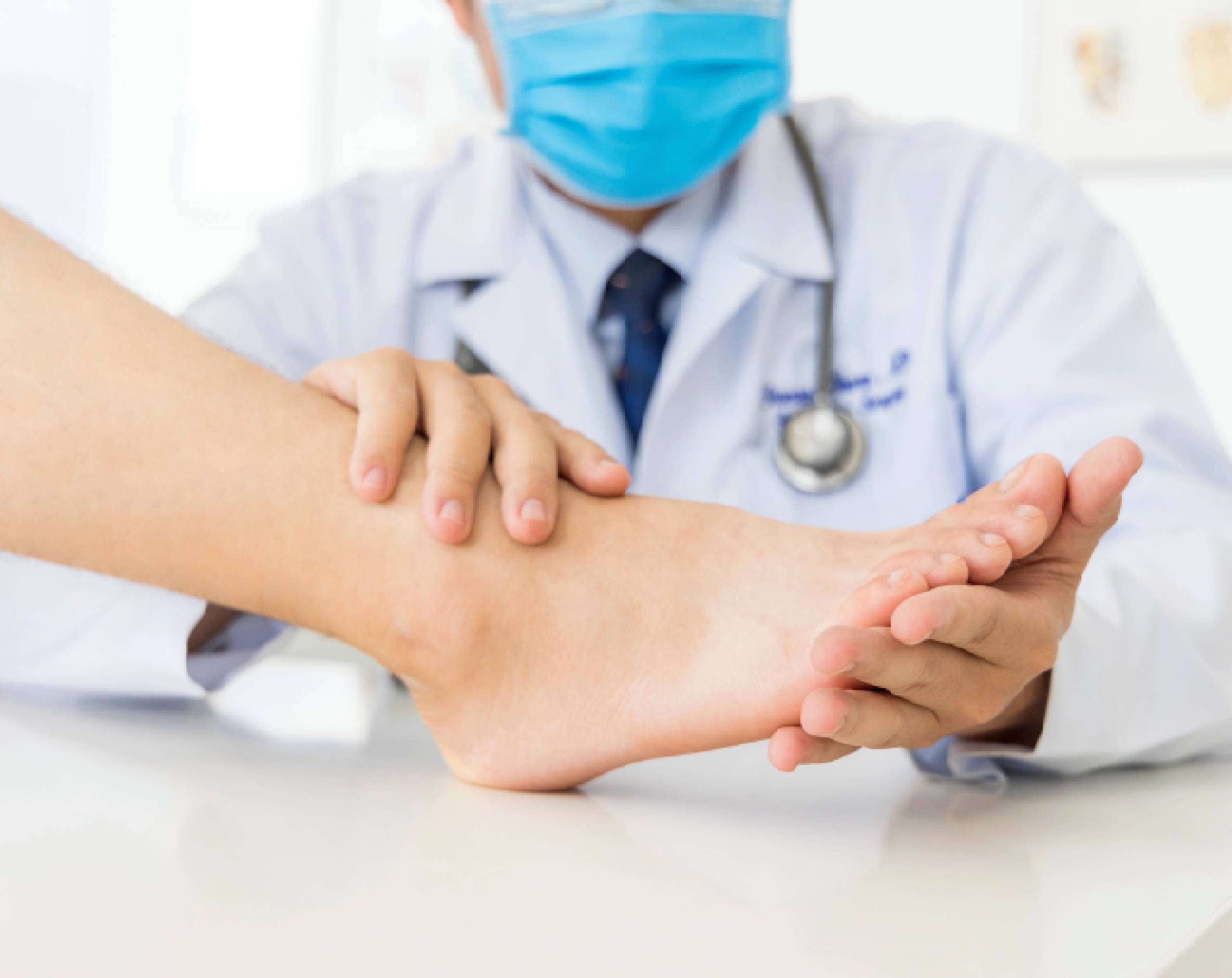 Médico dermatólogo revisando los pies de un paciente que sufre de hongos en las uñas.