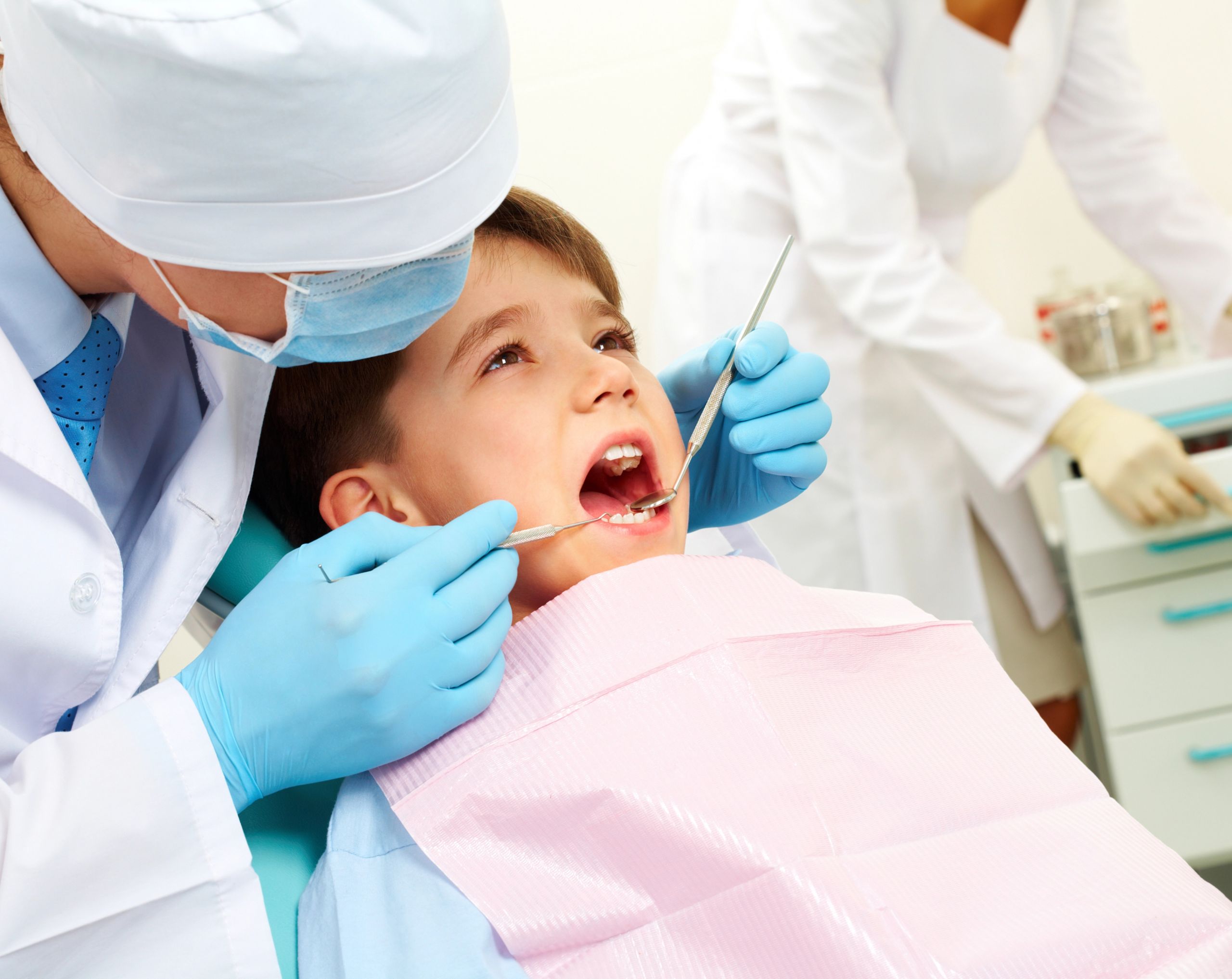 Niño pequeño en consultorio dental revisado por un odontopediatra durante la dentición.