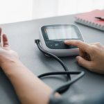 Hombre adulto mayor mide su frecuencia cardíaca con un monitor para evaluar un ritmo cardíaco bajo asociado a bradicardia sinusal.