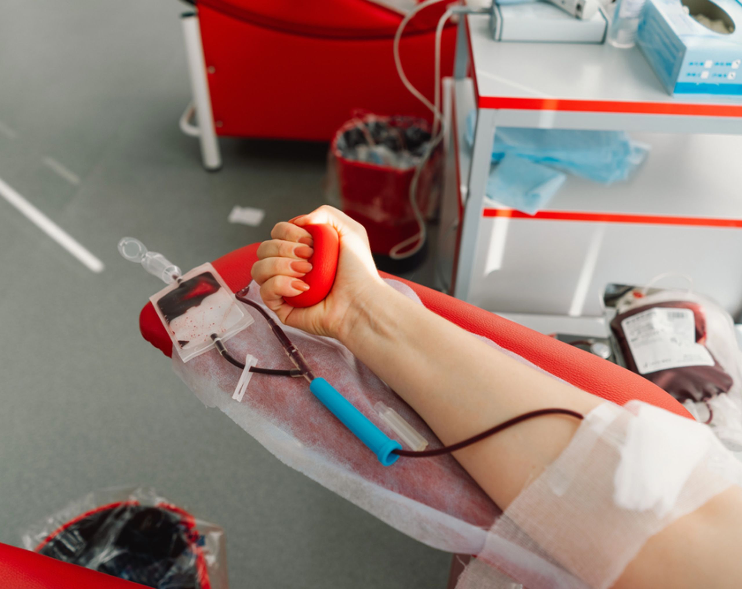 Mujer realiza una donación altruista de sangre en un hospital mientras sostiene una pelota de goma para favorecer el flujo sanguíneo. 